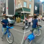 Stuntfietser balanceert bank op zijn hoofd in de drukte van New York